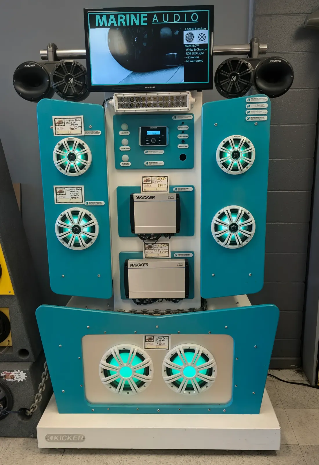 Kicker marine audio tower display with LED-lit speakers and subwoofers
