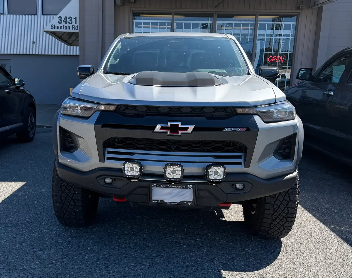 Auxiliary LED light pods installed on the front bumper of a lifted Chevrolet Colorado ZR2