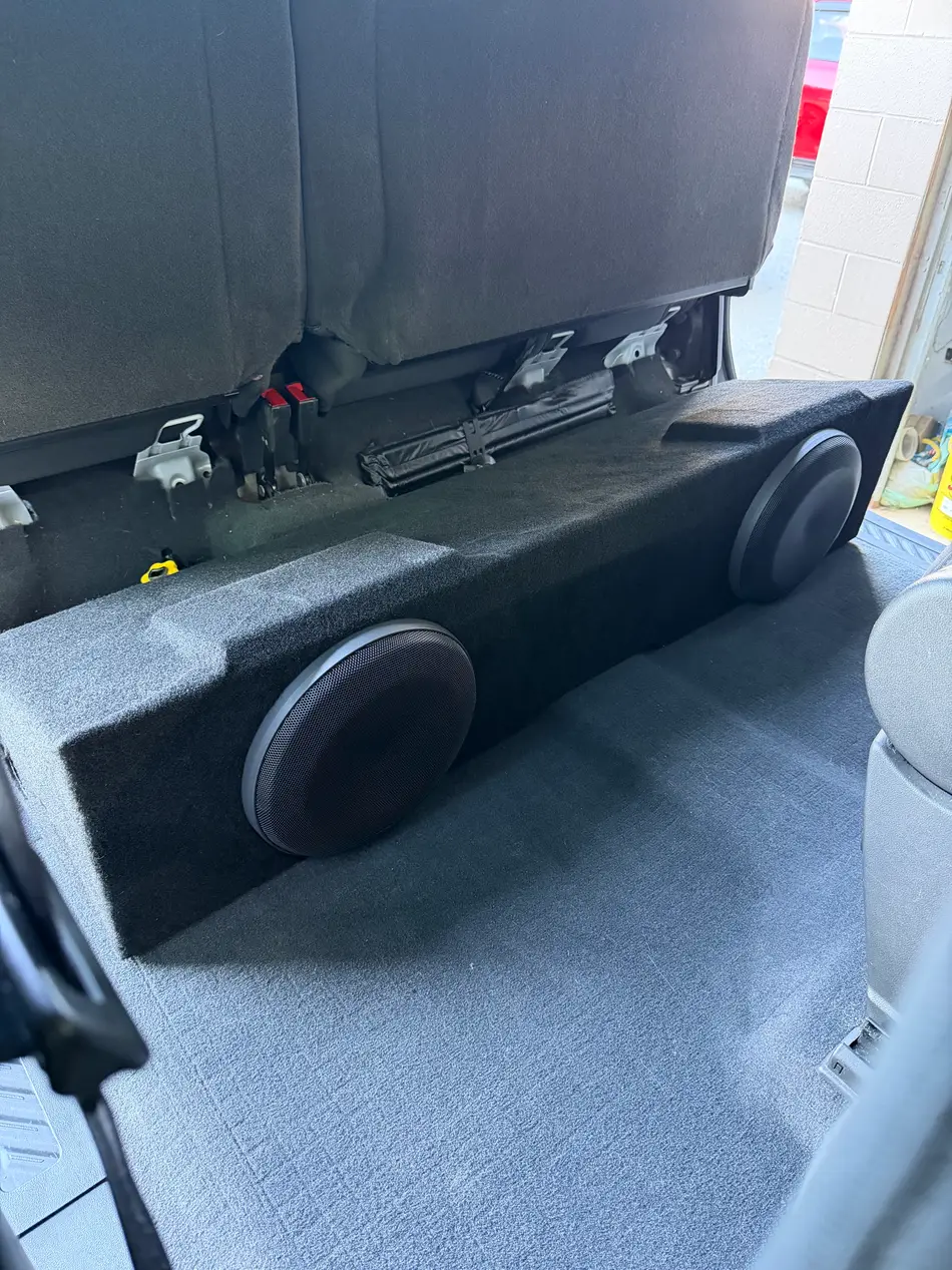 Dual flush-mounted subwoofers built into a factory-style rear cargo pocket