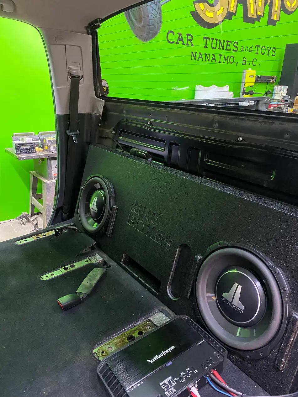 Dual JL Audio subwoofers in a custom-built enclosure with a Rockford Fosgate amplifier, wired in the cargo area